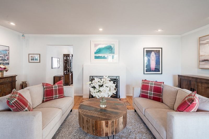 Large front sitting room with fireplace and beautiful surf art.