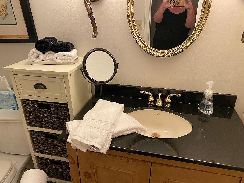 Cozy bathroom with mirrors, cabinets and plenty of towels and supplies