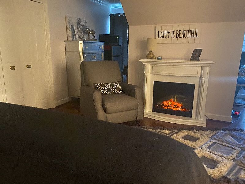 Electric Fireplace provides a cozy atmosphere. There is a chest of drawers and you can see in the background