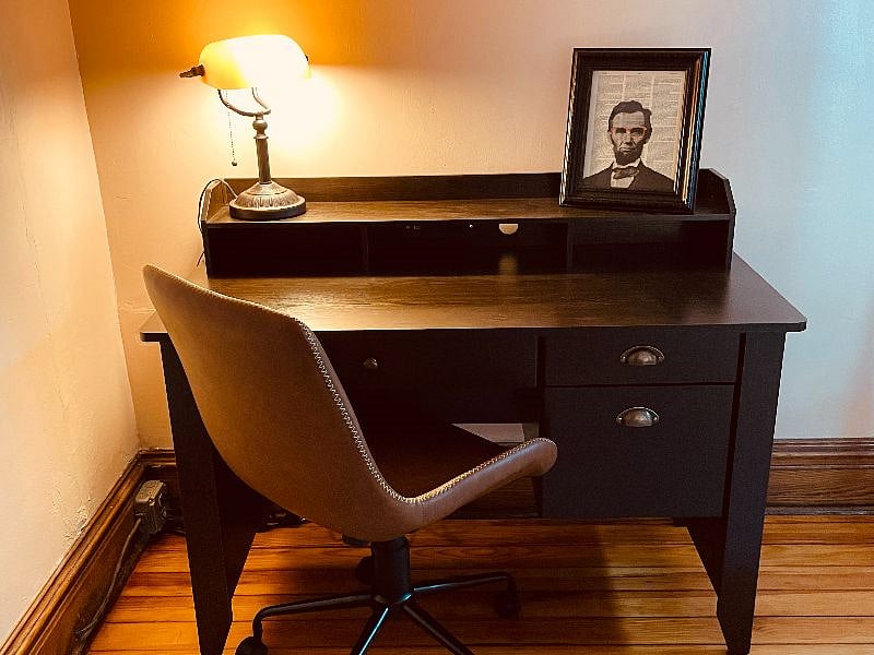 A separate office room has a desk set up to accommodate working from home.