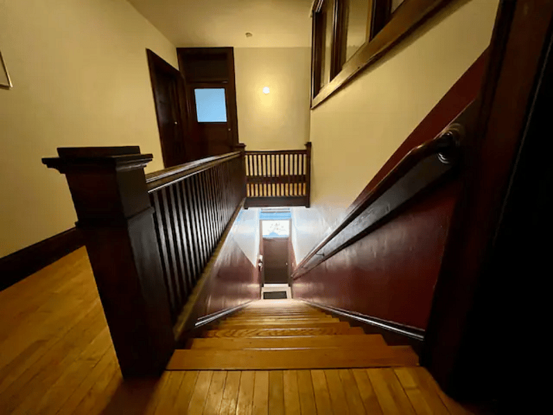 Entrance to apartment building at bottom of stairs.