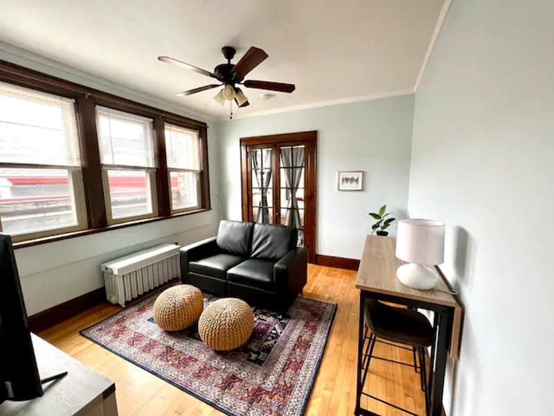 Living room with overhead fan, seating and eating area for two.