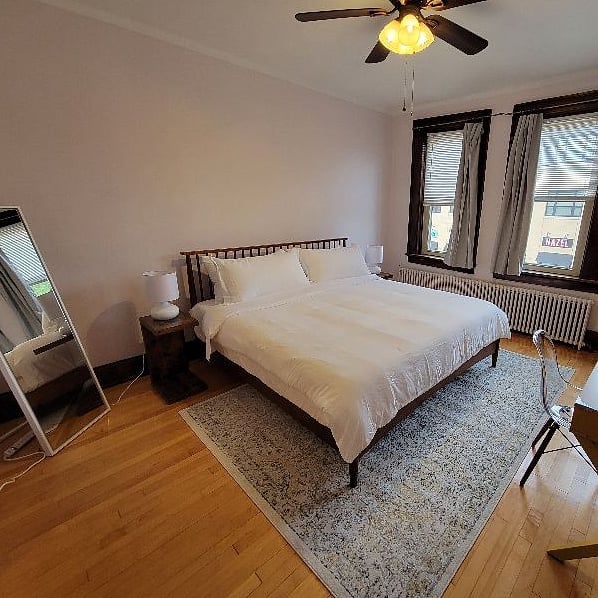 Front bedroom. Overhead fan, full size mirror, king bed and work space.