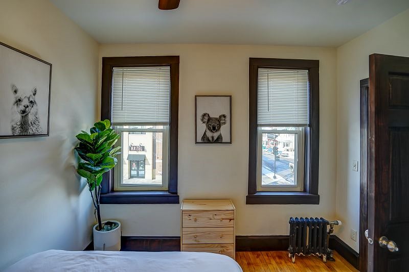 Bedroom. Two large windows for natural light and small clothes dresser.