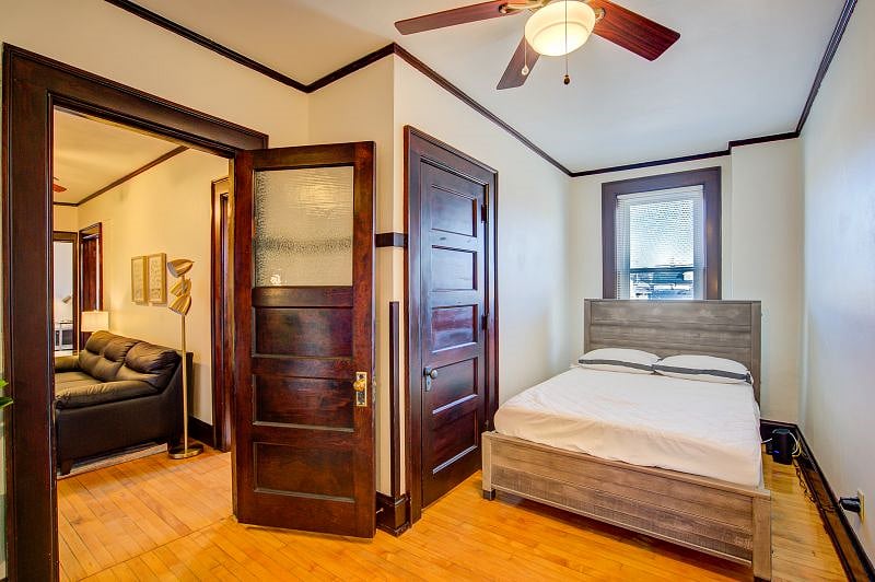 Bedroom has full sized bed and ceiling fan.