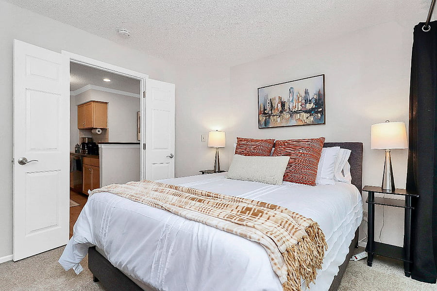 Cozy secondary bedroom featuring a new queen mattress with luxurious bedding and a smart TV.