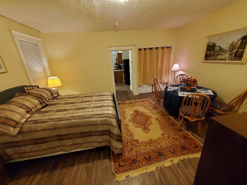 Bedroom includes queen bed dresser, and laundry access plus a bonus table that can be used as a desk area, gaming area, etc.