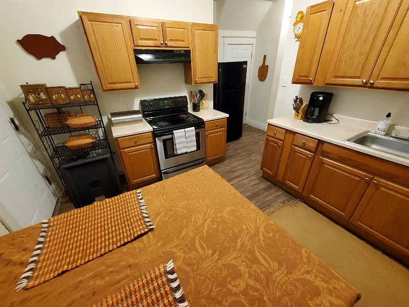 Full kitchen with full sized fridge, stove, sink, coffee maker, dishes, glasses, bowls, pans, and baking items
