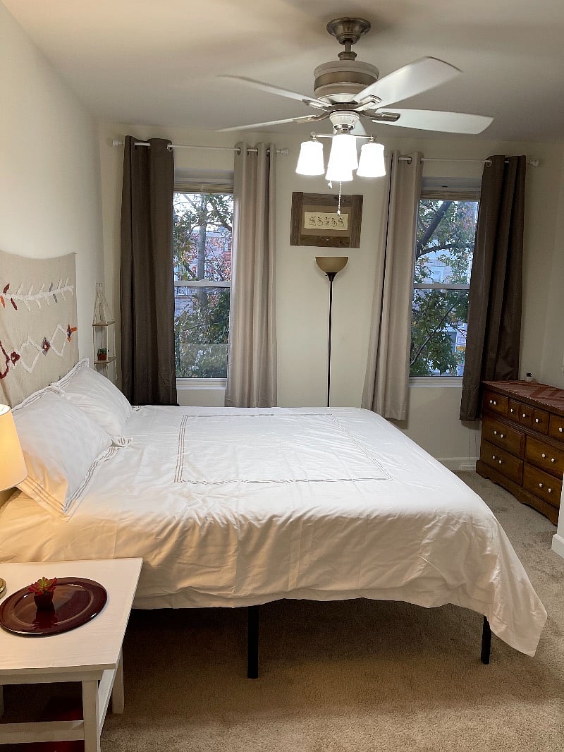 King size bedroom with black out curtains and ceiling fan