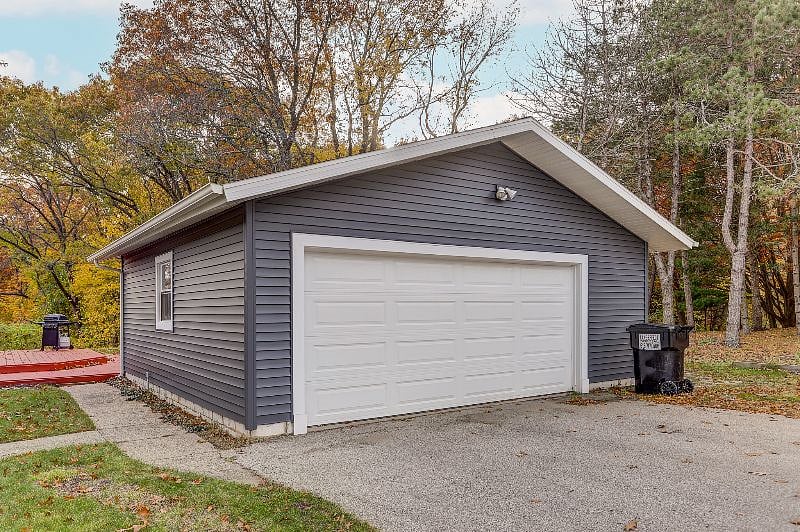 Garage view from the street. One car may be parked in the driveway. There is off street parking on the north side of the garage.
