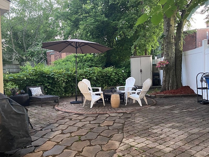 Backyard area equipped with grill/grill utensils and firepit for use by tenants. 