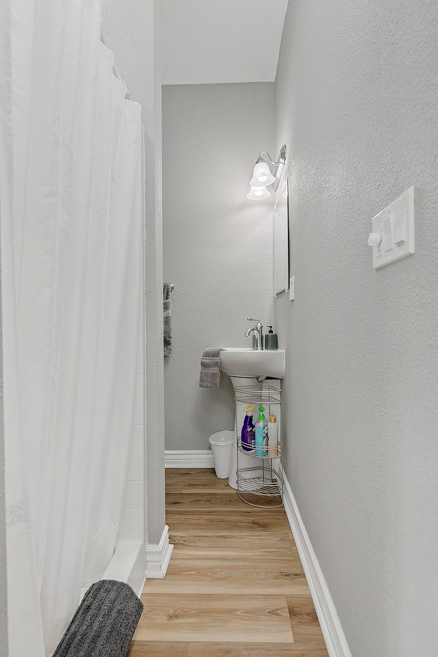 Petite bathroom with barn door. Sink, Shower, Toilet.