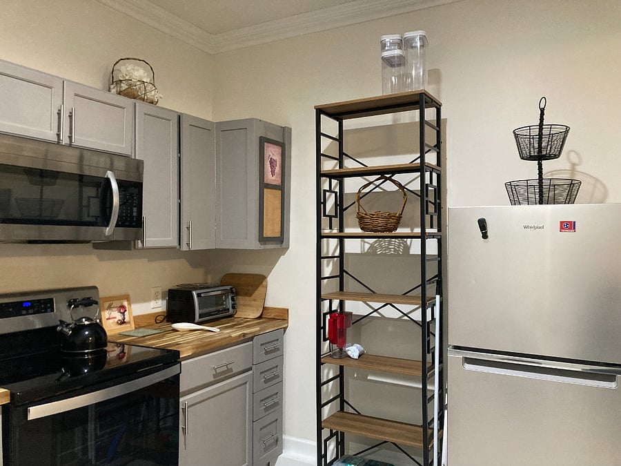 Kitchen stove, microwave, toaster oven, fridge and extra storage shelves for pantry items!