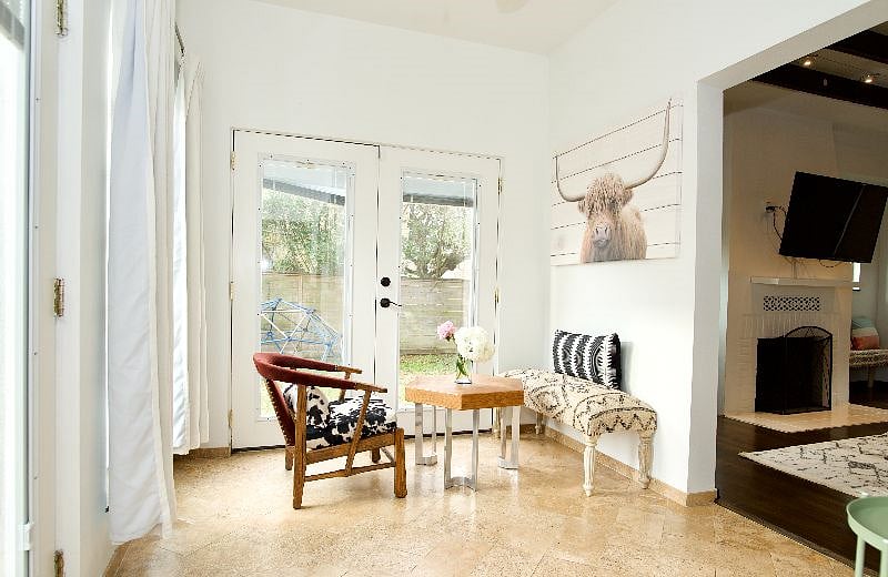 Sun-filled sunroom with picture windows and French doors.