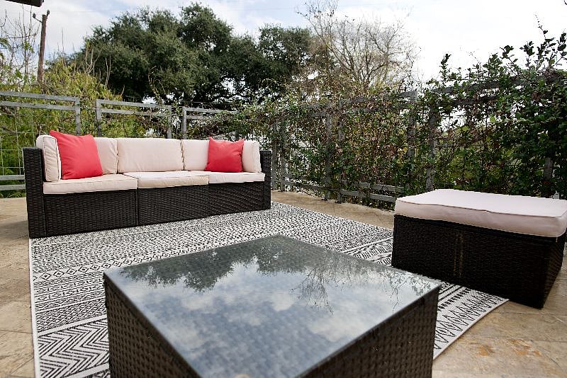 Balcony with furniture and vines along railing for added privacy