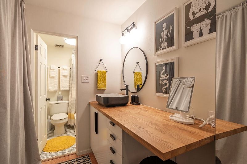 Extended 6' vanity and mirrored storage cabinets to right, as well as storage below. Lighted mirror provided and stool under counter.