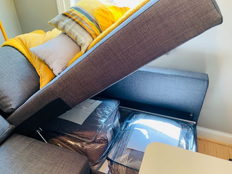 Bedding for the extra couch bed is neatly stored inside the couch