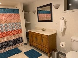 Full size bathtub and shower with shelves on both sides.