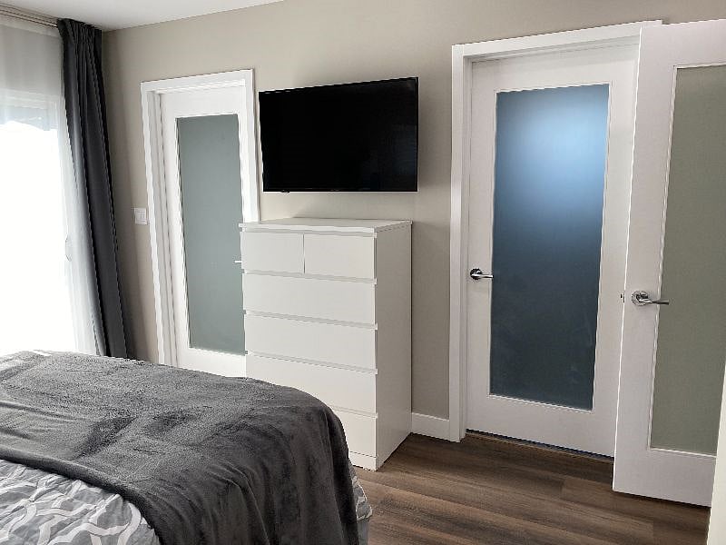 Queen size bed, 40" smart TV, access to walk in closet, bathroom, and sliding doors leading to a large deck and enclosed back yard.