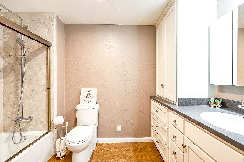 Deep soaking tub with cultured marble surround and relaxing rain shower.