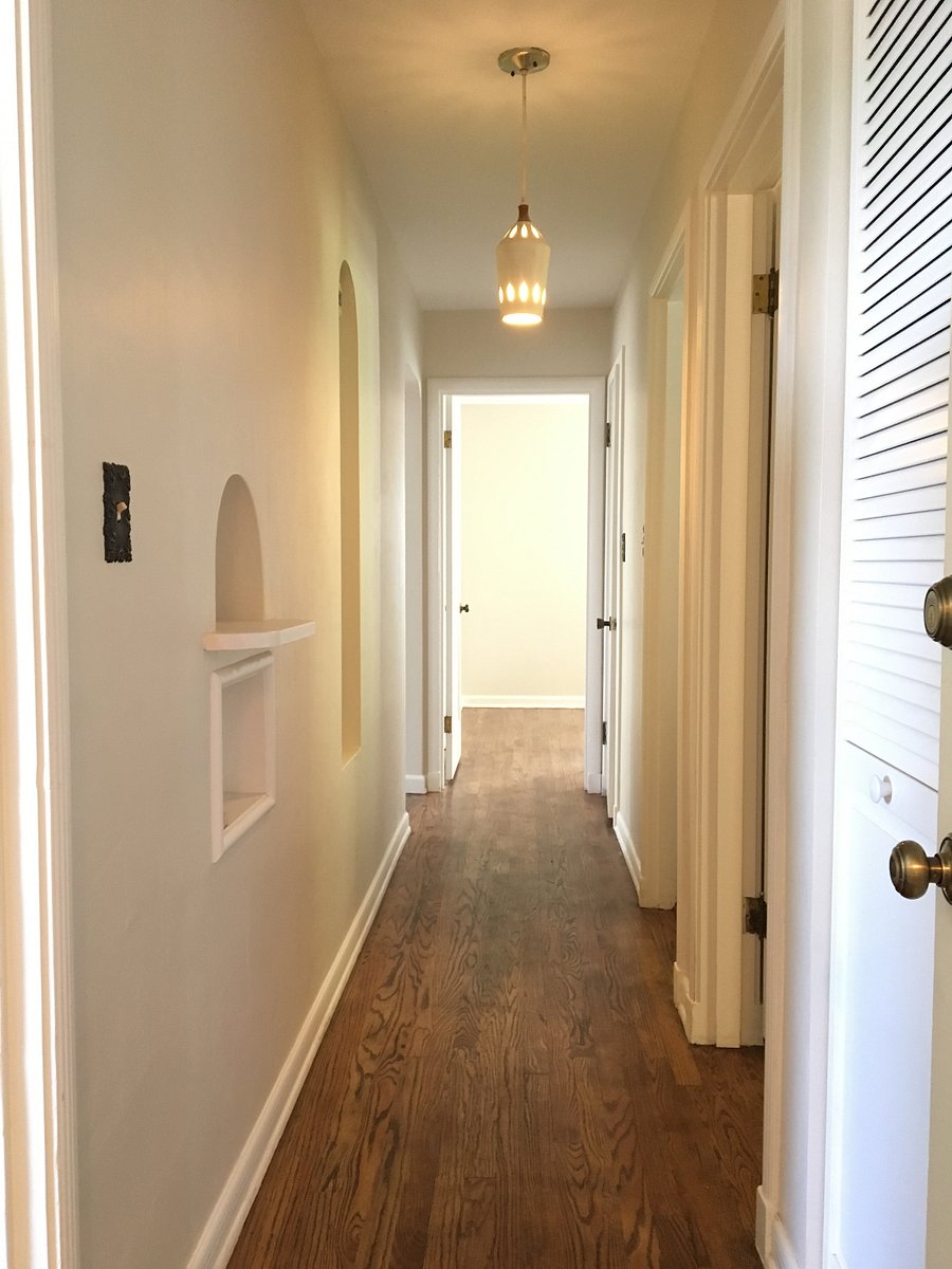View of the hallway.  The house has quality details of 1940's construction - arched doorway, crown molding, baseboards, wall niches