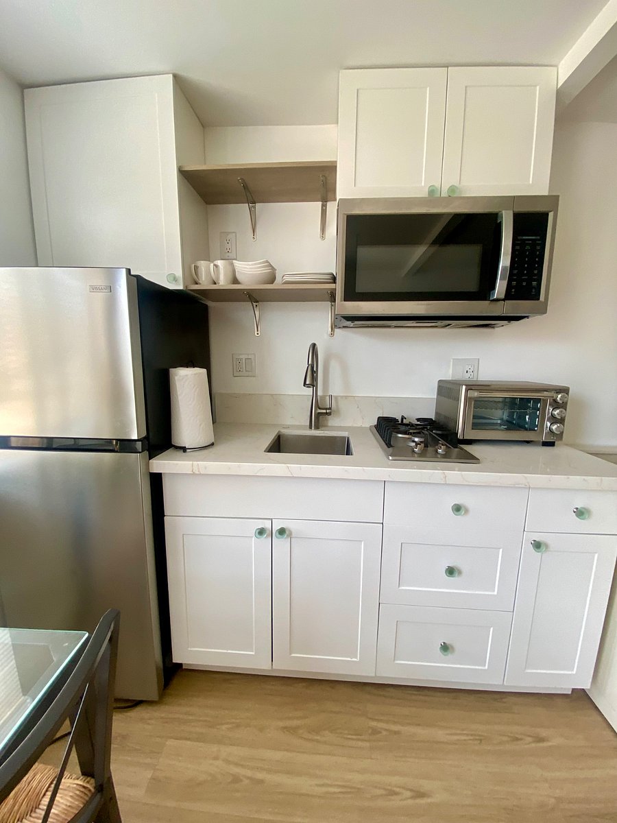 Kitchen counter, cooktop, toaster oven, microwave.