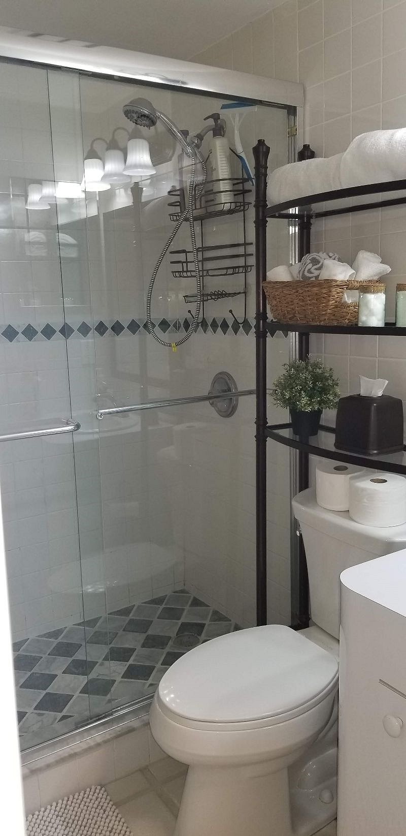 Tiled shower with plenty of racks on wall to hold towels and space for toiletries on shelf or under vanity.