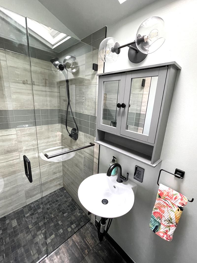 Modern bathroom boasts heated floor, walk-in shower, skylight and modern fixtures.