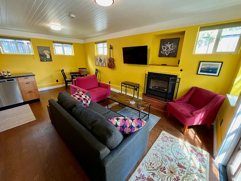 Sink into a relaxing couch with 43" smart TV, glowing gas fireplace, and cozy chairs.