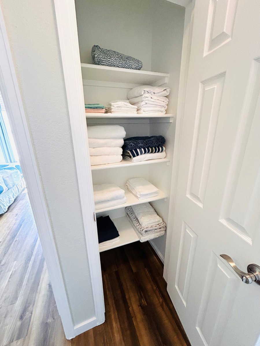 Linen closet with extra towels, pool towels, bed sheets, bathroom rugs, and shower curtains.