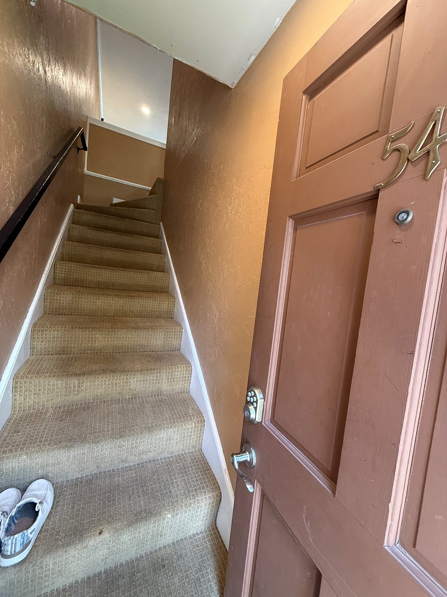 Open the front door, stairs lead the way to the apartment.