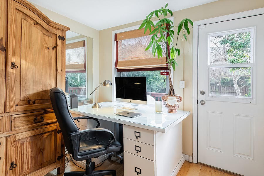 Large office desk with the in unit washer and dryer at other side of this room. The office/laundry room also leads to the upstairs private deck.