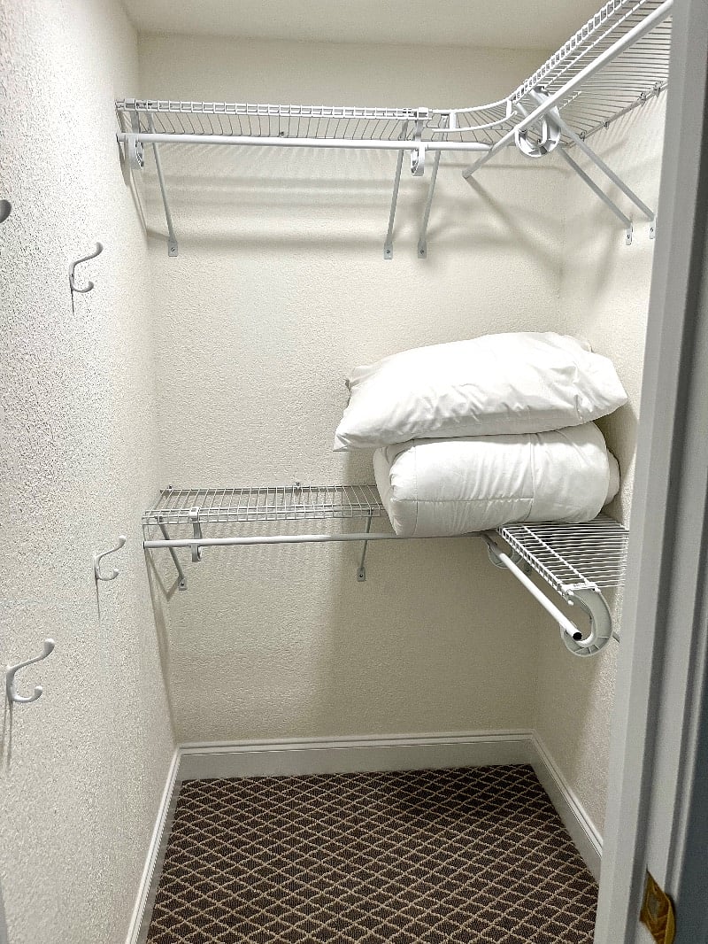 Walk in closet with extra bedding and towels. 