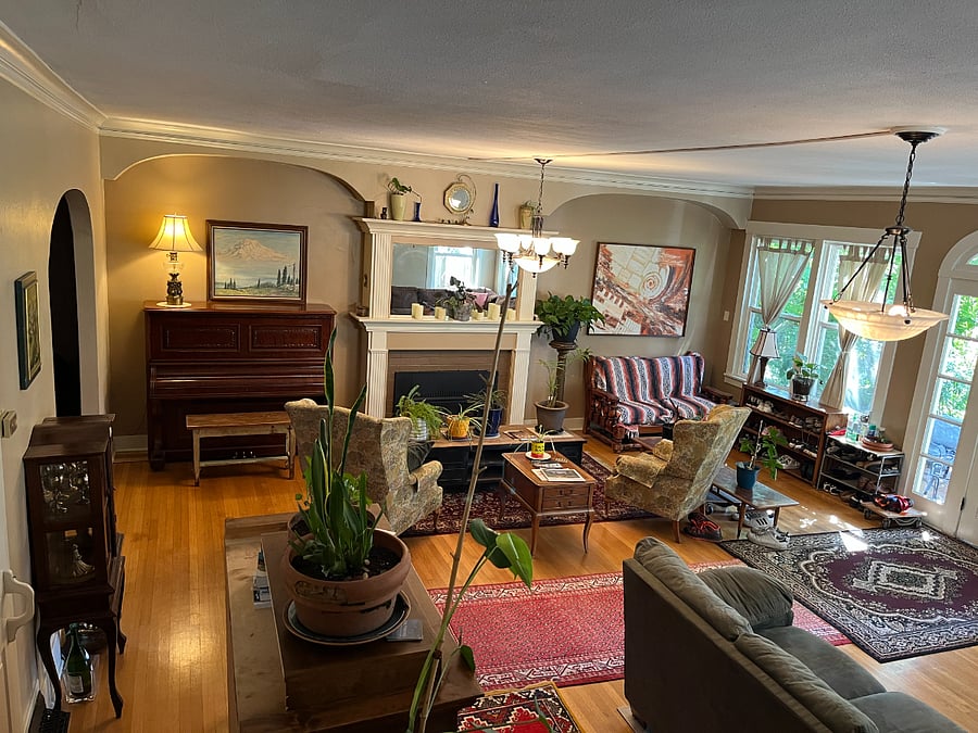 Main Parlor | Huge primary living room with comfy couches, wingback chairs, a gaggle of houseplants, and chill lounge vibes.
