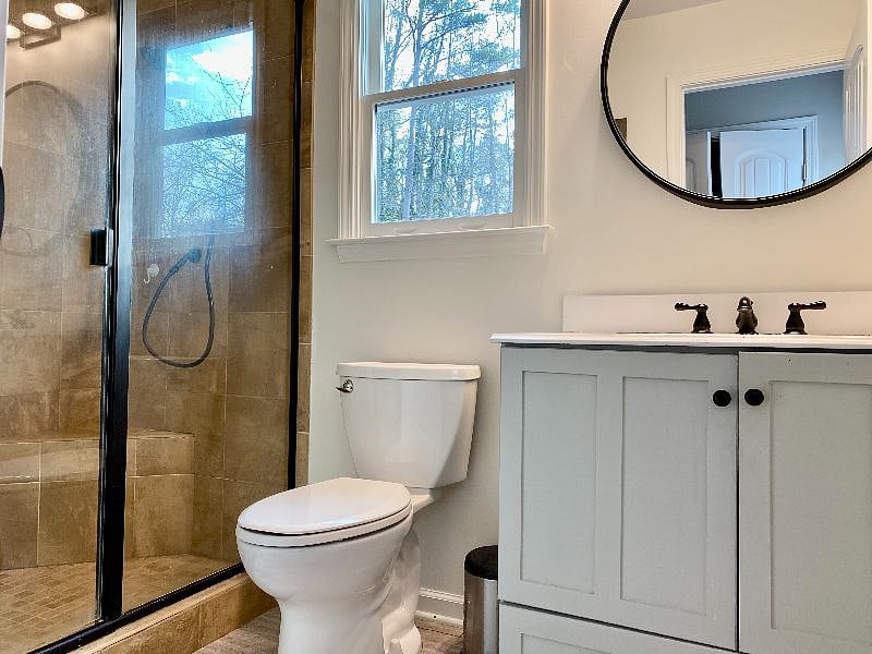 Bathroom has large walk-in shower with seat and pull-down shower head. Newly re-grouted.