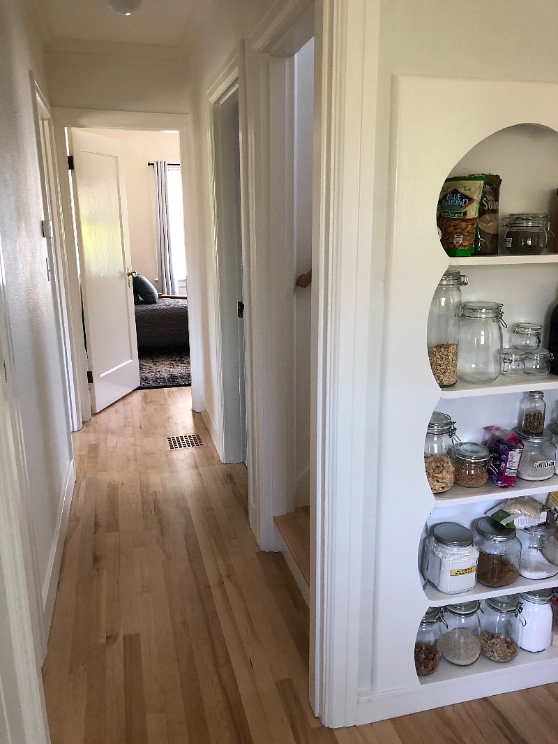 Kitchen to hall and main floor rental bedroom. Retained the built in scalloped edge staples pantry that's original to the house.