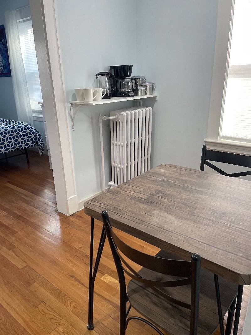 Drink station near dining area with coffee maker and electric kettle.