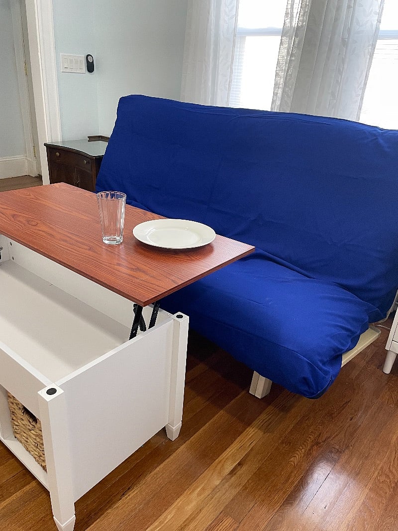 The table by the futon lifts up to become work or dining area.