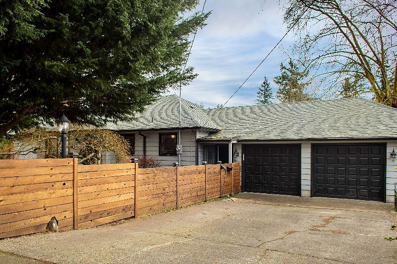 Apartment entrance is to the left of the garage behind the wood gate.