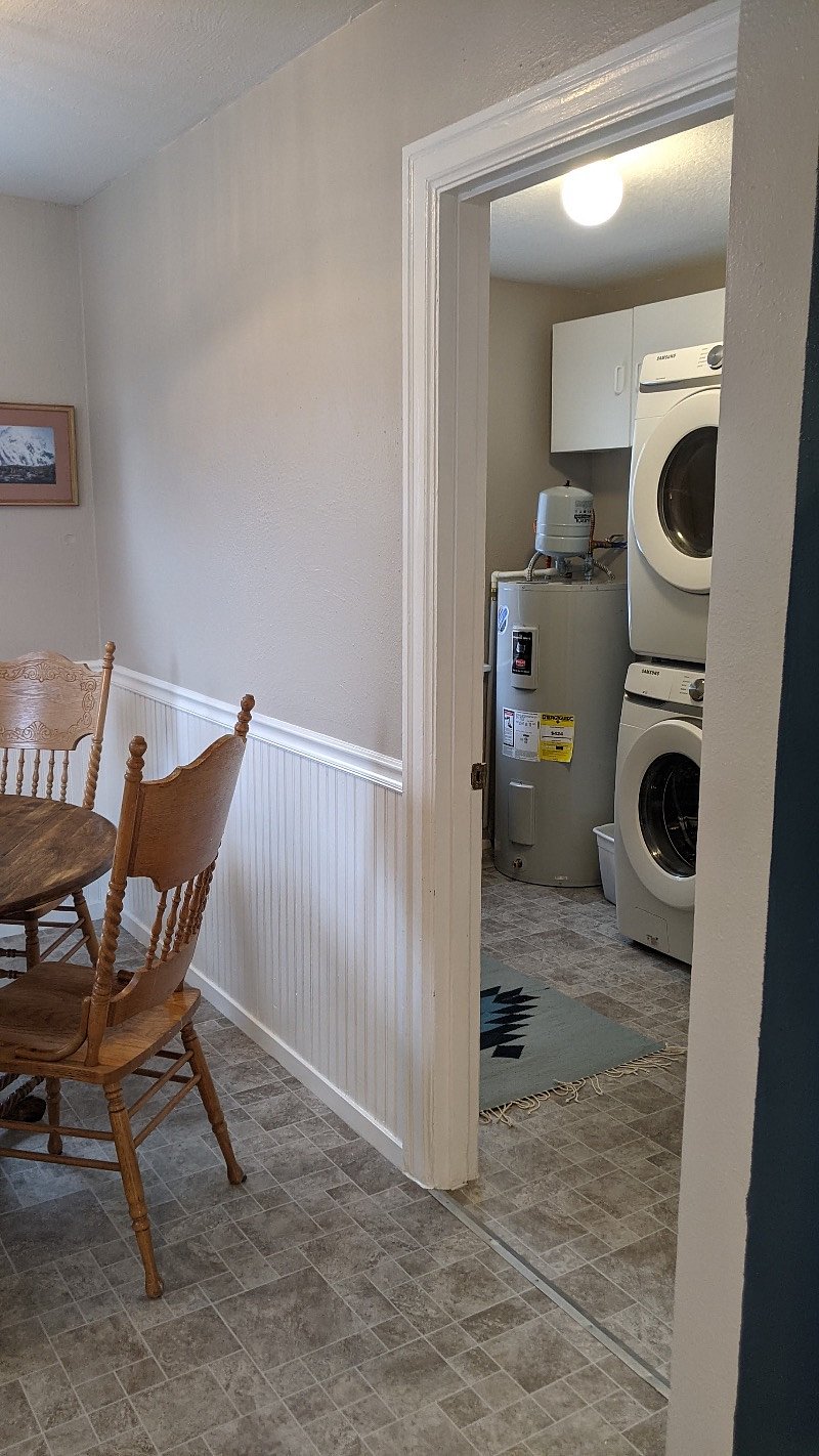 The laundry room is off the dining room, which is the back of the home where the door out back is.