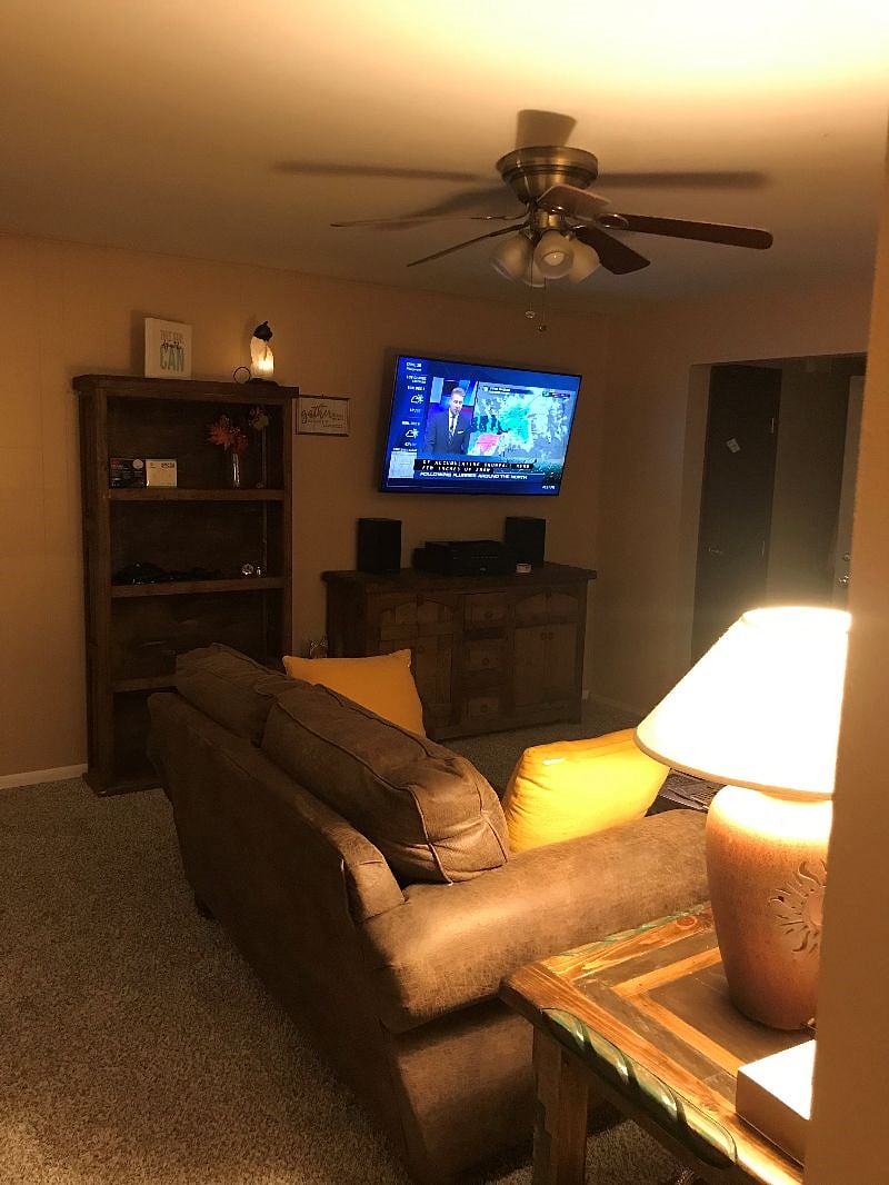 Living room showing 55" TV & bookshelf.