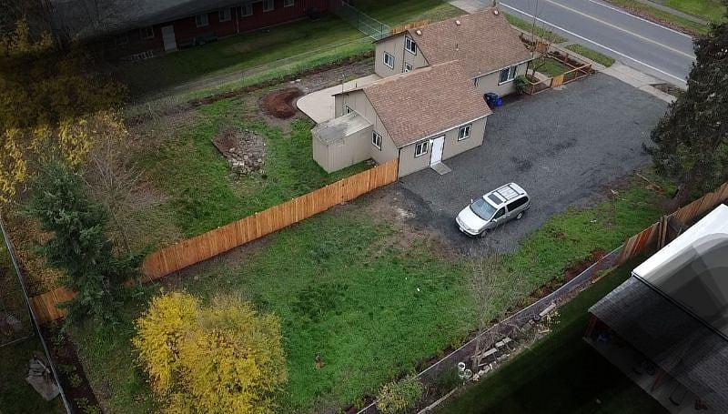 Aerial view of parking (right side of house and right side of fence) and backyard.