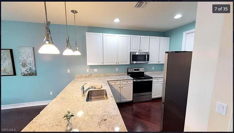 Large Kitchen with granite countertops and breakfast bar with stools