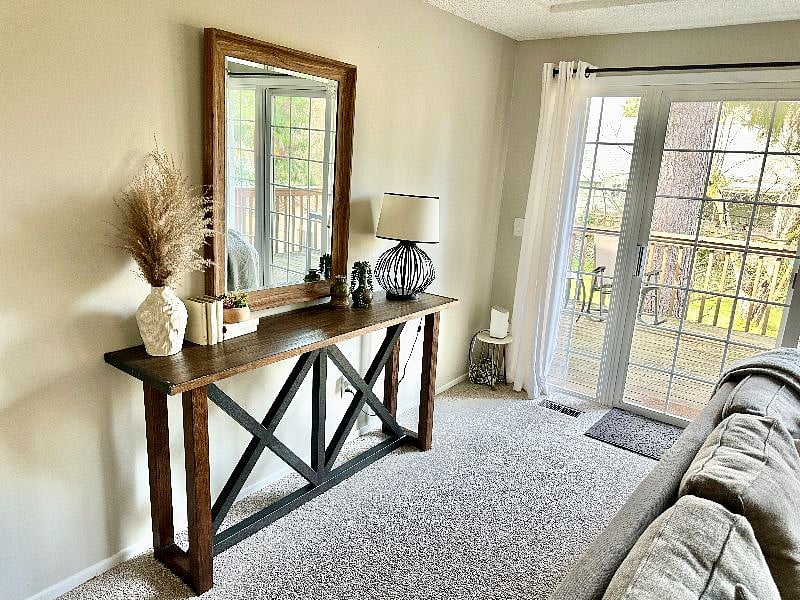 Living room with 65" smart TV with entry to deck overlooking large fenced in backyard.