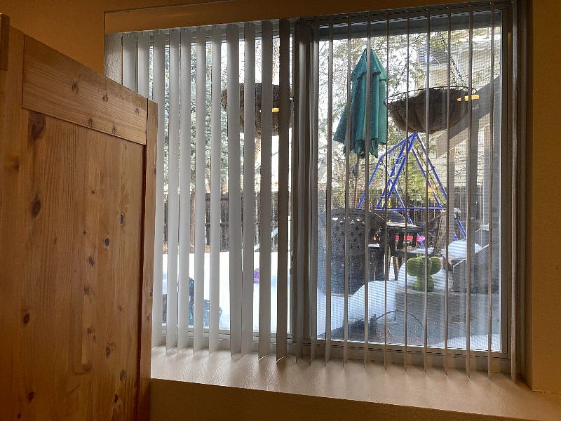 Lots of natural light between the two windows and French doors! Look out to back yard and side front yard. Blinds close to create dark room.