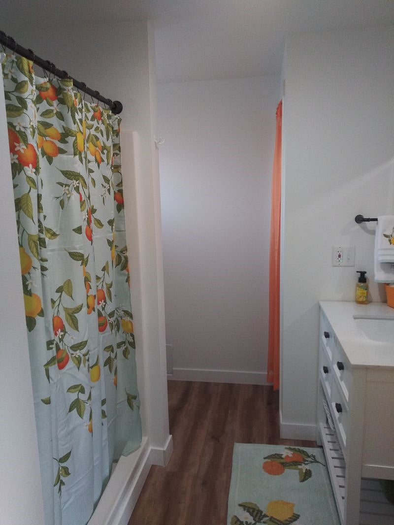 Full bathroom with walk in shower, vanity, toilet, closet and washer/dryer