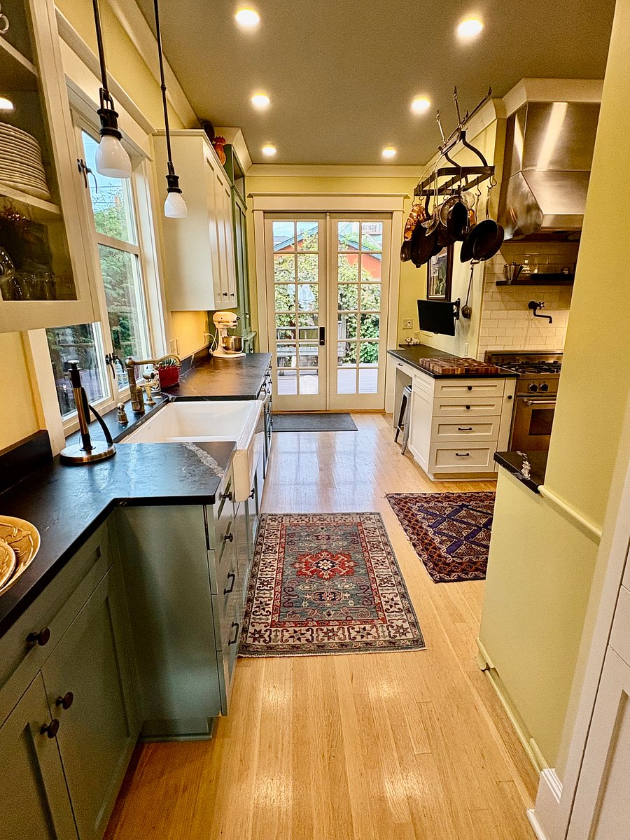 Kitchen looking east through french doors leading to large deck with sitting area and built in gas grill.