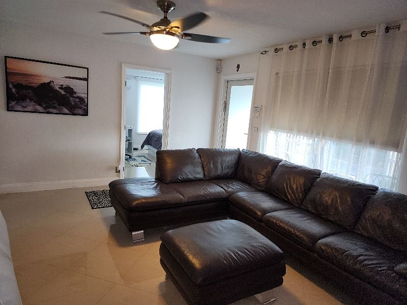 Another view of living room, entrance and door way to separate bedroom