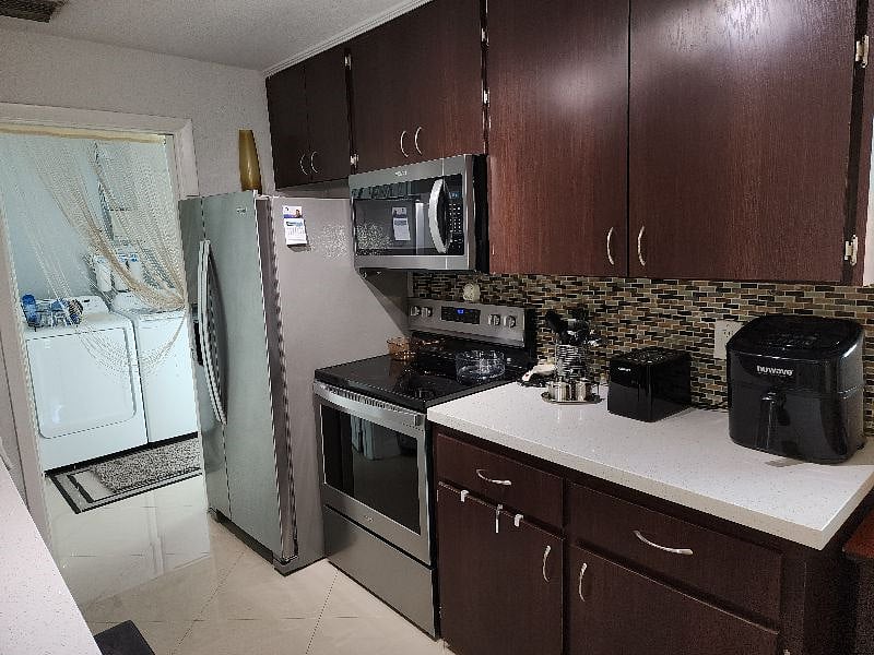 Kitchen view leading to laundry room and rear back yard access