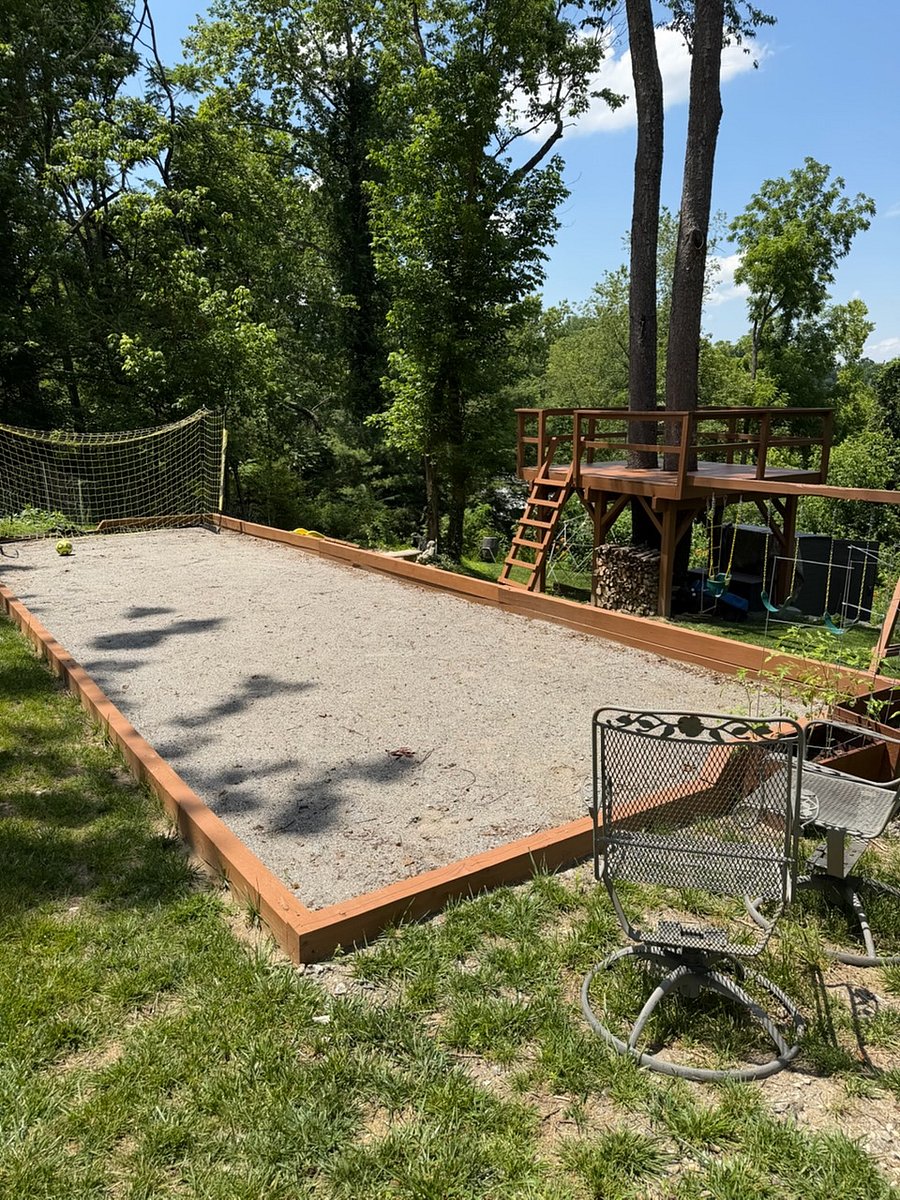 The backyard boasts a variety of activities for all ages including a multi-purpose court with gear for bocce, badminton, and soccer practice, a fire pit, tree fort with swings, slide, climbing wall, and geodesic climbing structure.